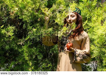 Armenian Young Woman In Traditional Clothes In The Forest With Pomegranate