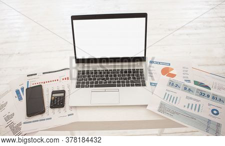Laptop On Table With Finance Statements, Calculator On White Background