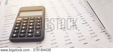 Calculator With Financial Statements On A White Background