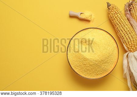 Bowl Of Cornflour Above View Isolated On A Yellow-colored Background. Polenta In A Bowl And Dry Corn
