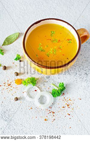 Homemade Chicken (bone) Broth/bouillon With Vegetables, Spices And Herbs In A Bowl (cup) On A Light 