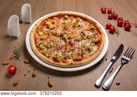Capricciosa Pizza Thin Cake, Tomato Sauce, Ham, Olives, Marinated Mushrooms Mozzarella Basil.
