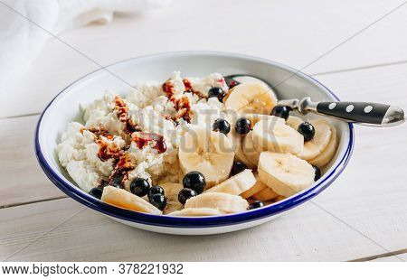 Organic Cottage Cheese With Date Syrup And Banana For Healthy Breakfast. White Wooden Table. Selecti