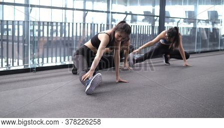 Group Of Sporty Young Asian Women In Sportswear Warming Up With Gymnastics And Stretching Exercises 