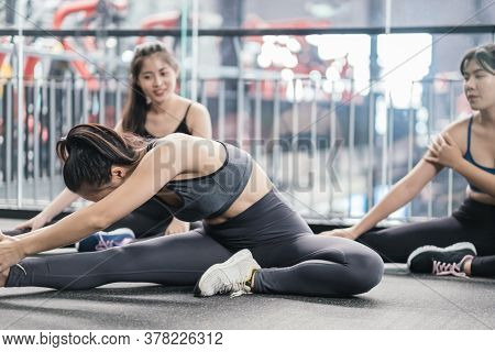 Group Of Sporty Young Asian Women In Sportswear Warming Up With Gymnastics And Stretching Exercises 