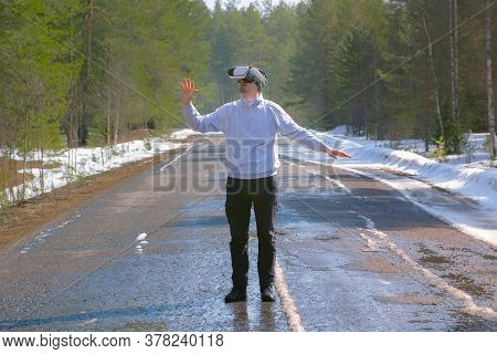 Man In Forest On Country Road In Vr Glasses Waving Hands And Turning Sides. Playing Games Or Watchin