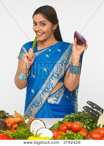 彼女のキッチンで野菜を持つ女性