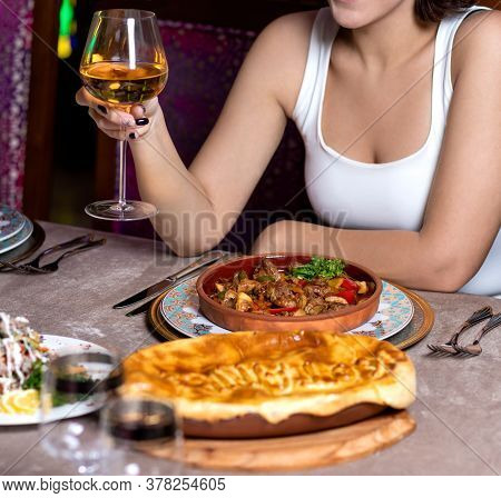 Woman Holding White Wine And Eating Meat Meal