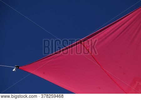Red Fabric That Is Stretched As Sun Protection For Pedestrians On The Street