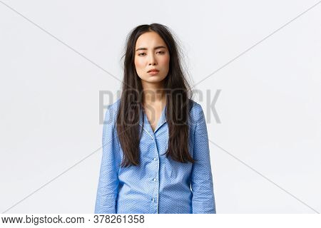 Exhausted Asian Woman With Messy Hair After Lying In Bed, Wearing Pajamas, Looking Tired With Sleepy