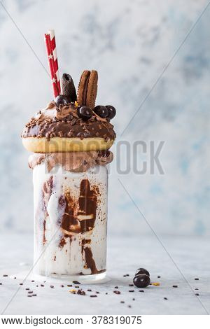Chocolate Indulgent Frosting Exreme Milkshake With Donut  And Sweets. Crazy Freakshake Food Trend. C