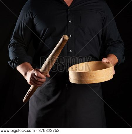 Man In Black Uniform Holding Empty Vintage Round Wooden Sieve For Sifting Flour And Rolling Pin, Che