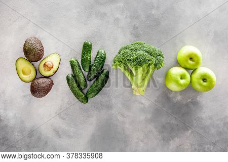 Green Vegetables Background. Сucumber, Avocado, Broccoli, Beans, Leek And Fresh Apple On Grey Stone 
