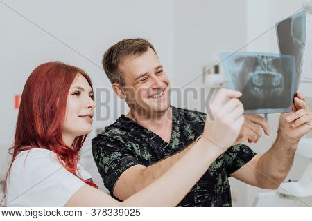 Doctor Dentist With An Assistant Check The X-ray Orthopantomogram. Dental Panoramic Radiography