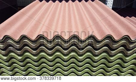 A Stack Of Green And Red Ondulin Sheets. Modern Roofing Material On Sale
