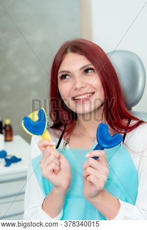 A Woman Demonstrates The Result Of Casts Of Her Teeth On A Spoon With Silicone Material