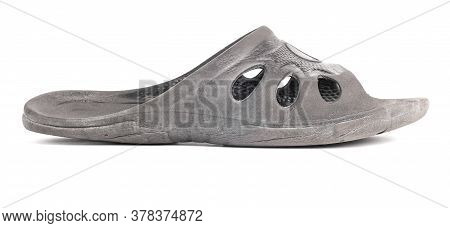 One Used Cheap Black Soft Rubber Slipper With Signs Of Friction Wear Isolated On White Background