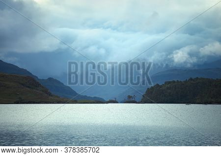 A View Of Scotland's Loch Morar. Taken Low On The Shoreline To Capture Foggy Clouds In The Distance.