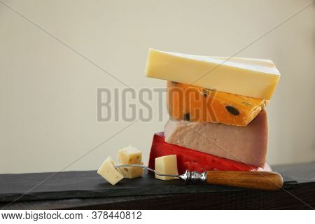 Different Types Of Delicious Cheeses And Fork On Slate Plate, Closeup. Space For Text