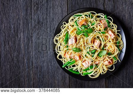 Spaghetti With Green Bean And Roasted Salmon Pieces, Decorated With Fresh Basil Leaves, Served On A 