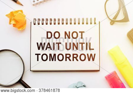 Writing A Note That Says Do Not Wait Until Tomorrow. Urgently Better To Do It Now. Copy Space On Bla