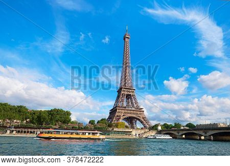 Cityscape Of Paris, France. Eiffel Tower On A Sunny Day, With Tourist Boats On River Seine. Bright S