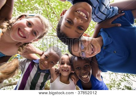 Children Embracing In Circle Around The Camera And Smiling