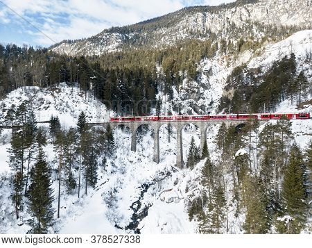 Filisur Switzerland - January 31. 2019: A Red Passenger Swiss Train Passing On The Schmitten Viaduct