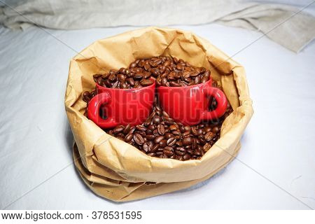 Red Ceramic Cups In A Paper Bag With Coffee Beans
