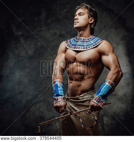 Athletic Man In Ancient Egyptian Costume Posing In The Studio, Proudly Looking Away