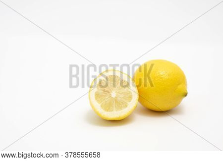 A Full Juicy Lemon And A Half On A White Background