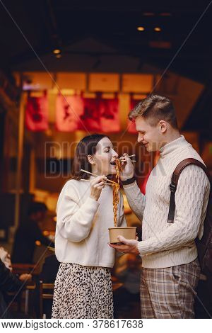 Newlywed Couple Eating Noodles With Chopsticks In Shanghai Outside A Food Market