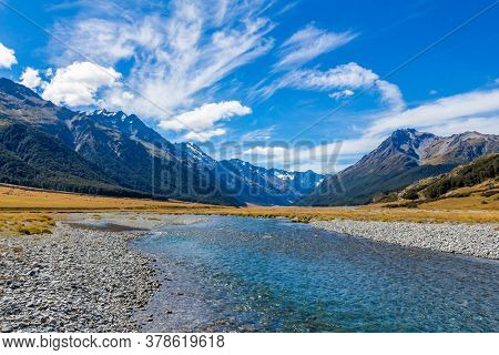 A Shallow, Fast, Upper Ahuriri River On A Sunny Day, Surrounded By Gravel, Rocks And Snow Capped Mou