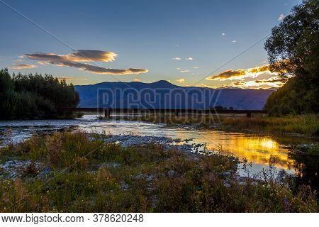 Sunset On The Tekapo River, With Mountains In The Background In Summer, Twizel, Canterbury, New Zeal