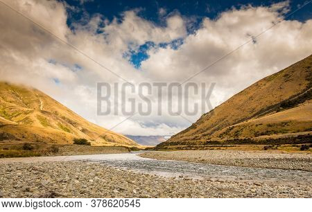 A New Zealand Mountain Stream, The Ahuriri River, In A V Shaped Valley With Dramatic Clouds In The B