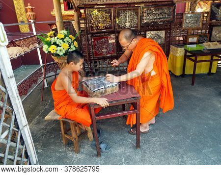 Chiang Mai, Thailand, December 6, 2018: Buddhist Monk Teaches His Student The Art Of Goldsmithing At