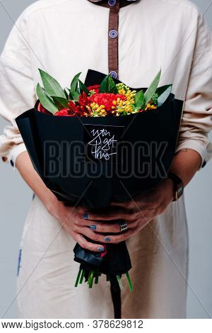 Bouquet Of Flowers In Black Package In The Hands Of A Woman Florist. Rose, Green Carnation, Asclepiu