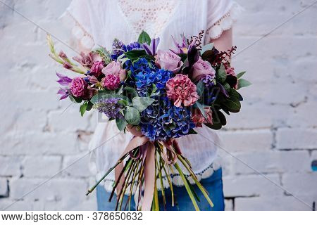 A Bouquet Of Flowers In The Hands Of A Woman On A Light Background. Bouquet Of Eucalyptus, Carnation