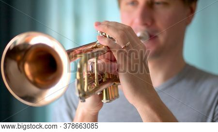 A Young Man Plays The Trumpet. Hands Of Musician. Close Up View.