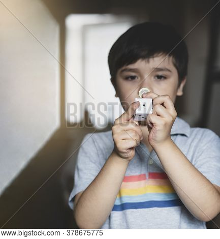 Blurry Face Of Kid Holding One Pound Coin And White Paper Dice Showing Number One With Copy Space Fo