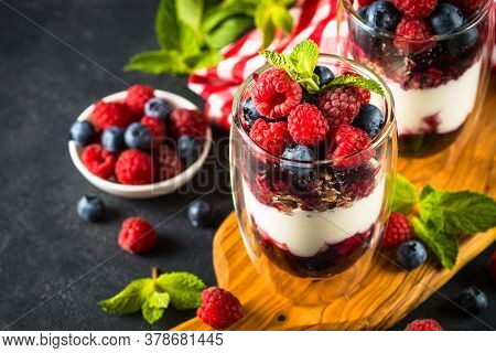 Parfait With Granola, Jam And Fresh Berries In The Glass Jar. Close Up. Healthy Dessert Or Snack.
