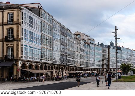 Corunna, Spain - July 20, 2020: View Of Marina Avenue With Unknown People Walking And Houses With Fa