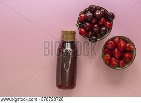 Summer Berry Juice In A Glass Bottle With Ripe Cherry And Strawberry. Top View, Copy Space For Text.