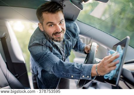 Close Up Portrait Of Smiling Handsome Caucasian Man With Beard Wiping Dust From Touchscreen Display 