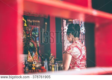 Blurred Soft Images Of An Asian Women Wearing A Red Cheongsam Standing In A Shrine To Pay Respect To