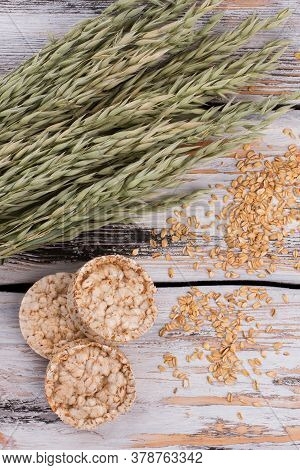 Oat Flakes, Spikelets And Crunchy Crispbread. Multi-grain Crispbreads With Grains And Ears On Wooden