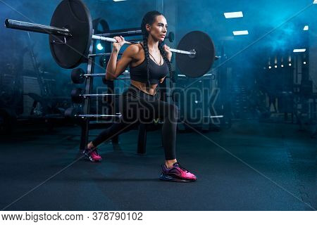 Gorgeous Brunette Female With Long Braids Doing Squats Using Barbell. Side View Of Srtong Concentrat