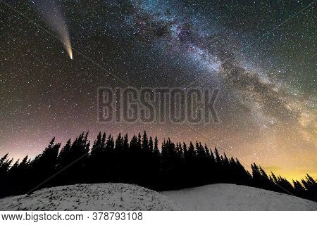 Surreal View Of Night In Mountains With Starry Dark Blue Cloudy Sky And Bright Comet With Light Tail