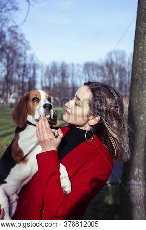 Pretty Young Girl In Redd Coat Playing With Dog Outside In Green Park, Lifestyle People Concept