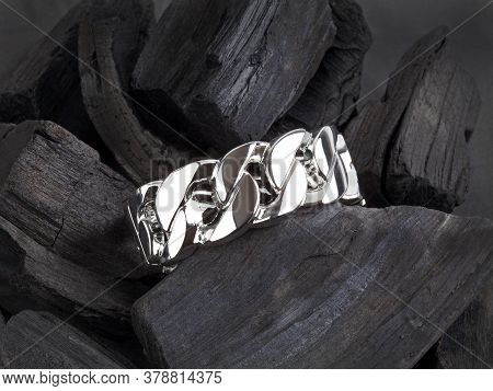 Women`s Wrist Bracelet Of Steel On Black Coal Background
